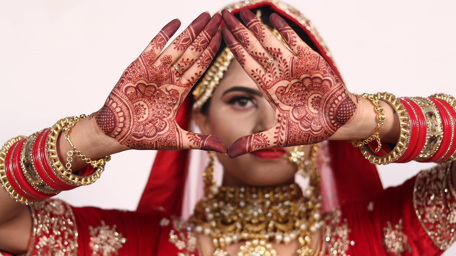 A Woman Wearing Lots of Accessories with Mehndi on Her Hand while Posing at the Camera
