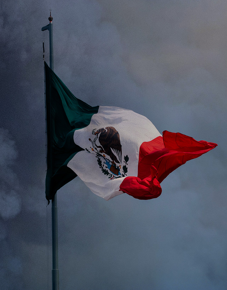 Image of Mexican flag with dark smoke behind it
