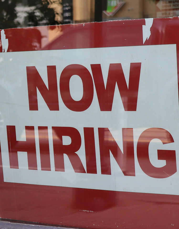 Now Hiring sign in a window